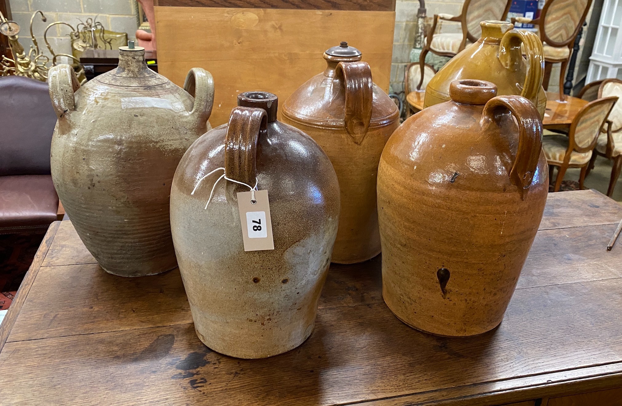 Five earthenware and saltglazed flagons, three with light fittings attached, largest height 41cm